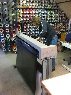 Laila fester vinylrullen som skal brukes i spesialprinteren som skal skjære ut bokstavene.