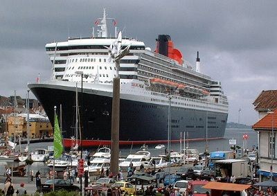 Queen Mary 2 ruver over torghandlerbodene - og småbatene på havna i Stavanger