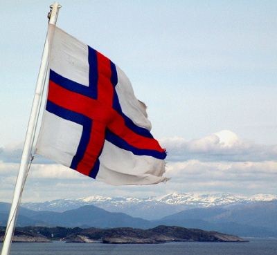 'Norrøna' legger Norge bak seg. Det Færøyiske flagget blafrer friskt i havbrisen ute ved Marsteinen  syd for Sotra. I bakgrunnen kan man se isbreen Folgefonna.