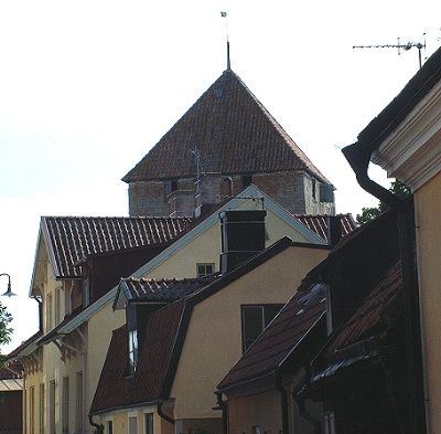 Gammel bebyggelse i Visby- med et kirketårn i bakgrunnen