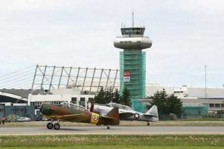 De to North American Harvardene LN-TEX og LN-WNH passerer tårnet ved Stavanger Lufthavn Sola.