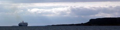 Queen Mary 2 fortsatte  nordover langs kysten . Til høyre ligger øya Bru og i bakgrunnen skimtes det sørlige delen av Karmøy