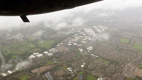 Så, etter drøye halvannen eler knappe to timer i luften dukker Manchesters forsteder opp under de regnfylte skyene