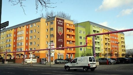 Ostel holder til i en bygård fra rundt 1960. Den opprinnelig  "DDR-gråe" ombygningen er blitt mere fargerik etter "Murens" fall i 1989