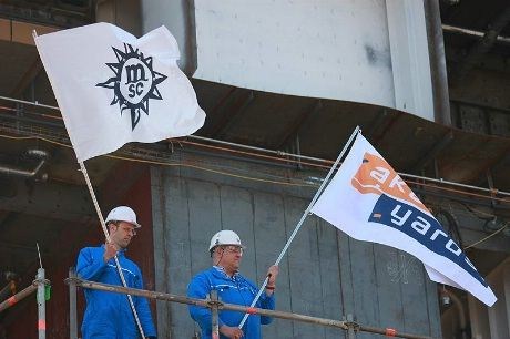 Mannskap fra Aker Yards vaier flagg fra de to samarbeidspartnerne